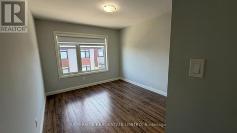 A room with a window and wooden flooring.