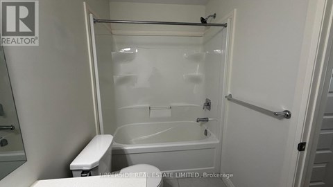A white bathroom with a tub, toilet and sink.