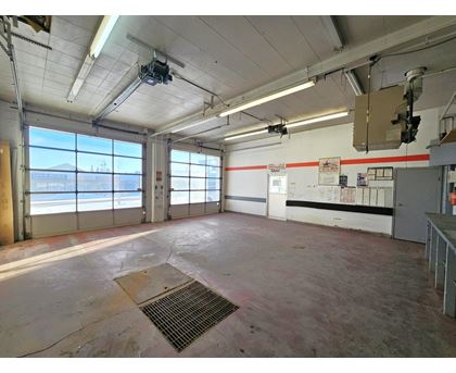 A large, empty room with a metal grate on the floor.