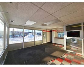 A car dealership with a black carpet and a checkered floor.