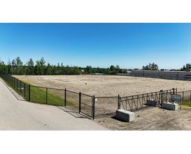A fenced area with a gate and a signboard.