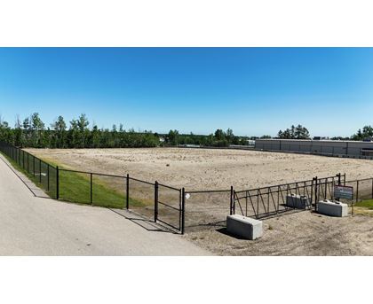 A fenced area with a gate and a signboard.