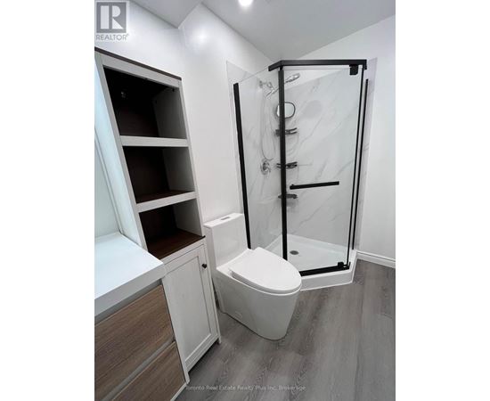 A white toilet in a bathroom with a walk-in shower.