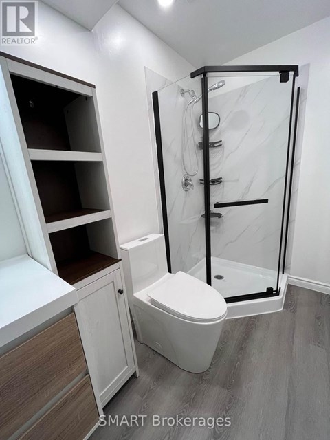 A white toilet in a bathroom with a walk-in shower.