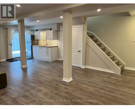 A spacious room with a staircase leading to the upper floor.