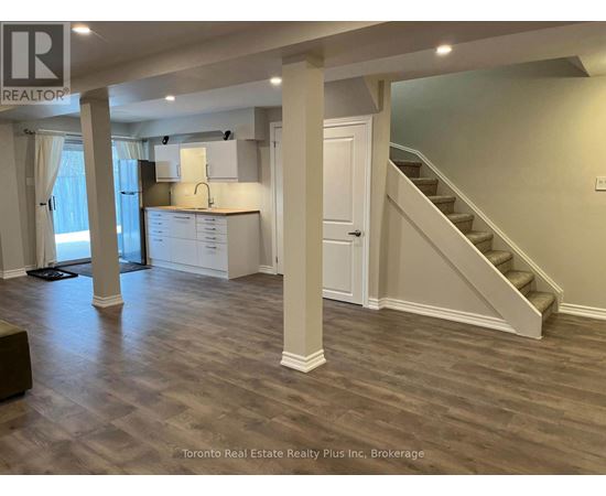A spacious room with a staircase leading to the upper floor.