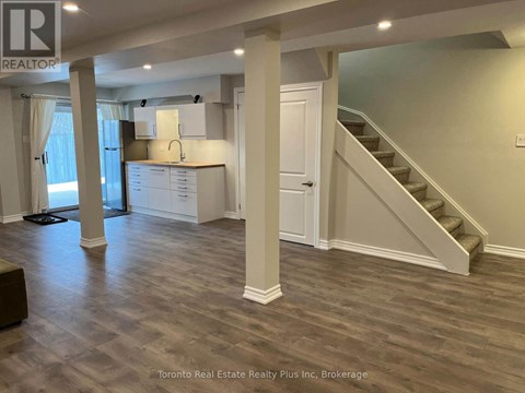 A spacious room with a staircase leading to the upper floor.