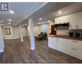 A spacious kitchen with white cabinets and a microwave above the stove.