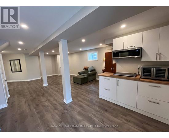 A spacious kitchen with white cabinets and a microwave above the stove.