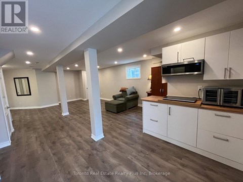 A spacious kitchen with white cabinets and a microwave above the stove.