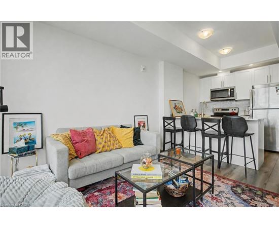 A living room with a grey couch and a glass coffee table.