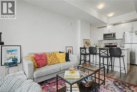 A living room with a grey couch and a glass coffee table.