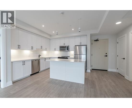 A modern kitchen with white cabinets and a central island.