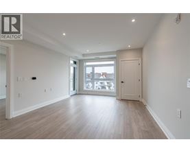 A spacious room with a sliding glass door leading to a balcony.