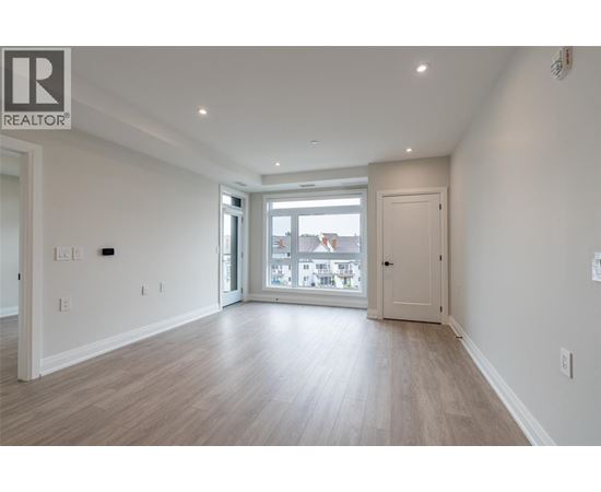A spacious room with a sliding glass door leading to a balcony.