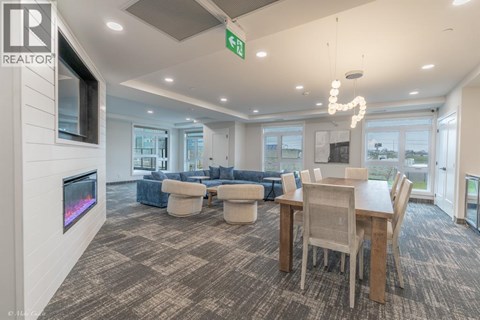 A living room with a grey carpet and a wooden dining table.