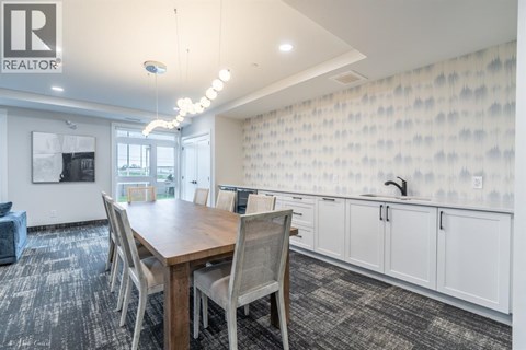 A dining room with a wooden table and chairs.