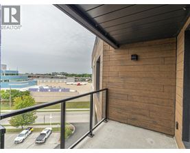 A balcony with a view of a parking lot and a pool.