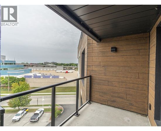 A balcony with a view of a parking lot and a pool.