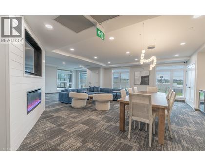 A living room with a grey carpet and a wooden dining table.