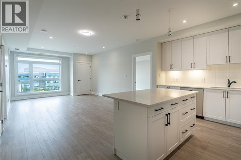 A spacious kitchen with white cabinets and a large island.