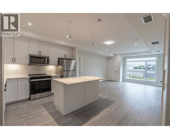 A spacious kitchen with white cabinets and a large island.