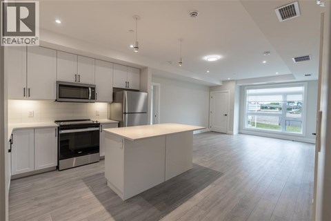A spacious kitchen with white cabinets and a large island.