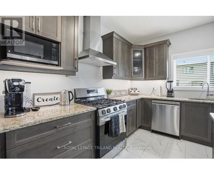 A modern kitchen with dark wood cabinets and stainless steel appliances.