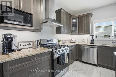 A modern kitchen with dark wood cabinets and stainless steel appliances.