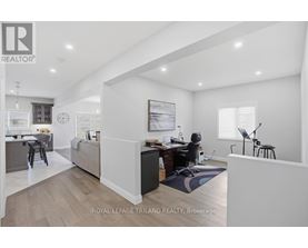 A well-lit, spacious room with a desk and a chair in the corner.