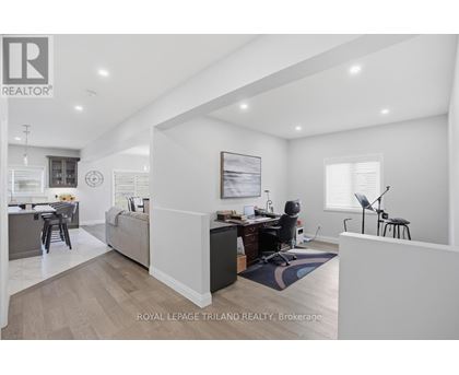 A well-lit, spacious room with a desk and a chair in the corner.