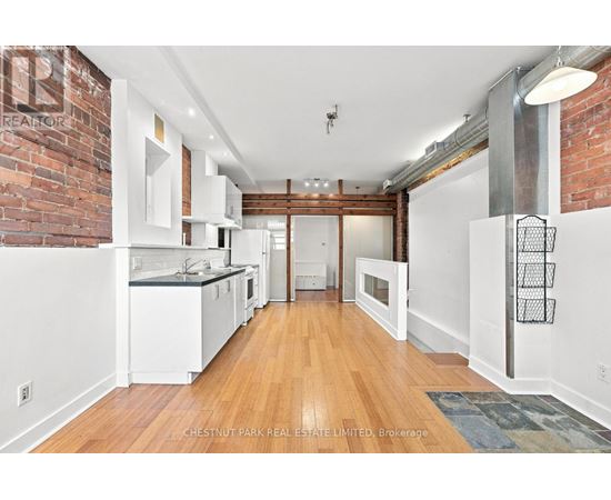 A kitchen with white cabinets and a brick wall.