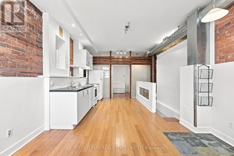 A kitchen with white cabinets and a brick wall.