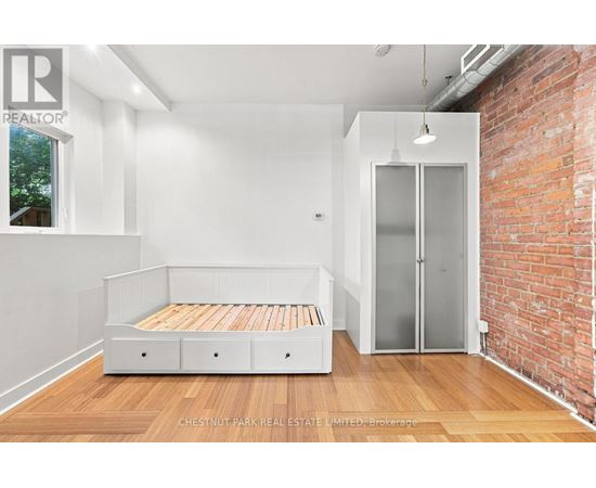 A bedroom with a bed and a brick wall.