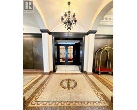 A hallway with a chandelier, a trolley, and a mosaic floor.