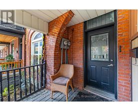 A black door is on the right of a brick archway.