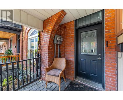 A black door is on the right of a brick archway.