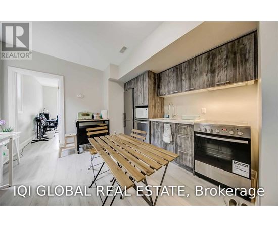 A modern kitchen with a wooden table and stainless steel appliances.