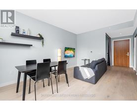 A modern dining room with a black table and chairs.