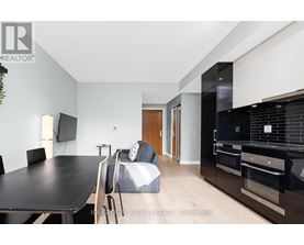 A modern kitchen with a black countertop and stainless steel appliances.