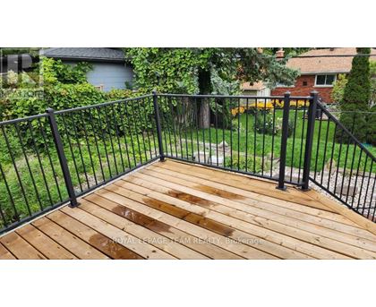 A wooden deck with a black railing.
