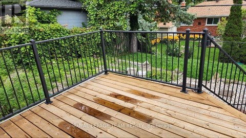 A wooden deck with a black railing.