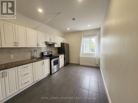 A kitchen with white cabinets and a tiled floor.