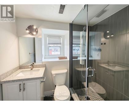 A bathroom with a toilet, sink, and shower.