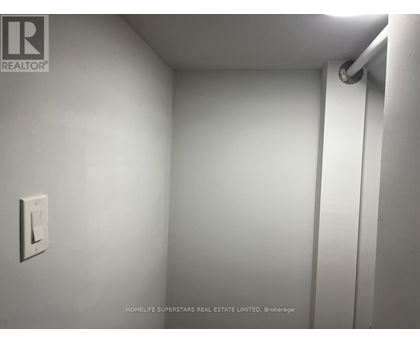A white wall with a light switch and a pipe.