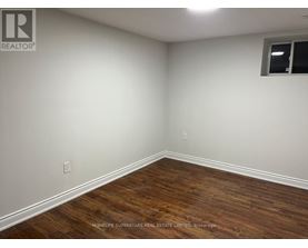 A room with wooden flooring and white walls.
