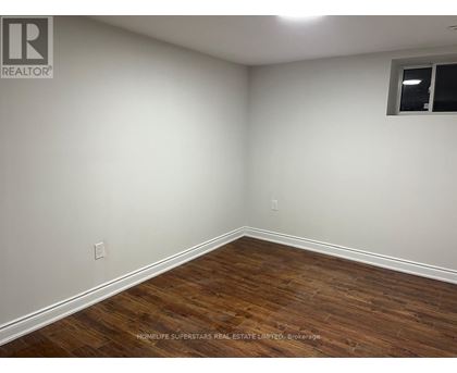 A room with wooden flooring and white walls.
