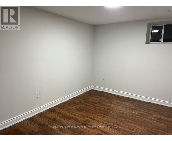 A room with wooden flooring and white walls.