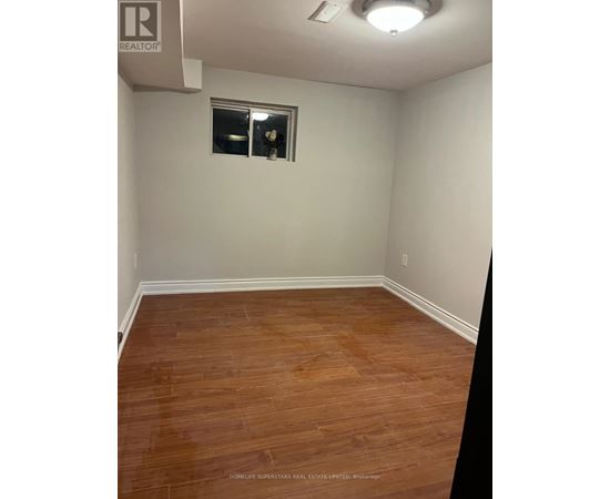 A room with a wooden floor and a window.