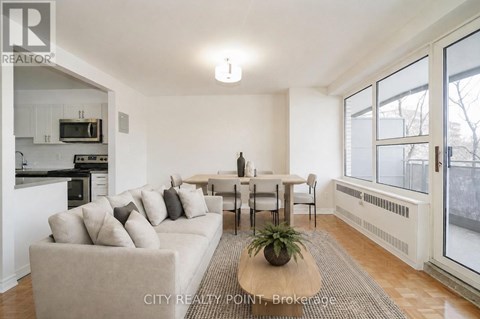 A living room with a couch, a table, and a potted plant.